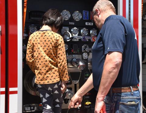 Greg Probst (right) tells Tai Siferd about all the knobs on the fire truck