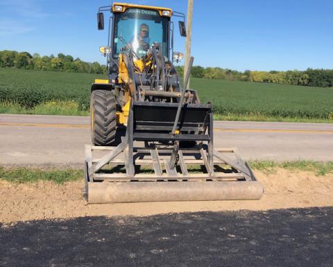 Don Snyder compacting fill dirt along the pathway