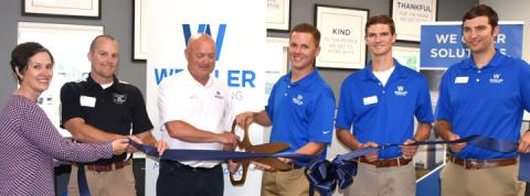 Paula Scott of the Bluffton chamber and Jesse Blackburn, village administrator, join the Wessler team in its ribbon cutting.