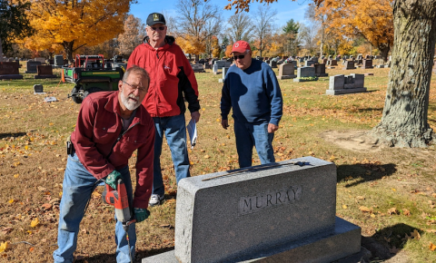 Legion members install holders on veterans' graves
