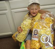 Young Elam Suter with sample bags of Shirley's Gourmet Popcorn