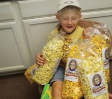 Young Elam Suter with sample bags of Shirley's Gourmet Popcorn