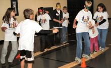 Youngsters at last weekend^aEURTMs children^aEURTMs conference at Bluffton University help their blindfolded teammates during a team-building relay game in Burcky Gym. Bluffton^aEURTMs Lion and Lamb Peace Arts Center hosted the conference, ^aEURoeCelebration of Peace: A Bridge Between Us,^aEUR