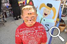 Adam Belcher shows off his painted face from Thursday's kid's art activities - these continue on Friday