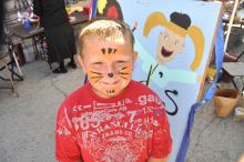 Adam Belcher shows off his painted face from Thursday's kid's art activities - these continue on Friday