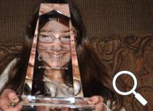 Elizabeth Nisly smiles behind her spelling bee trophy