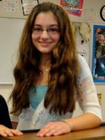 Elizabeth Nisly smiles behind her spelling bee trophy