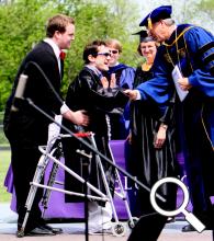 Marcus Meyers (center) receives his diploma and congratulations from Dr. James Harder, Bluffton University president, during Bluffton's commencement ceremony on May 6. Aiding Meyers is one of his 2011-12 personal care assistants on campus, fellow student Evan Skilliter.