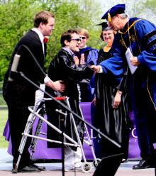 Marcus Meyers (center) receives his diploma and congratulations from Dr. James Harder, Bluffton University president, during Bluffton's commencement ceremony on May 6. Aiding Meyers is one of his 2011-12 personal care assistants on campus, fellow student Evan Skilliter.