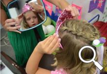 Regan checks her princess crown as Vanessa Wilson holds the mirror
